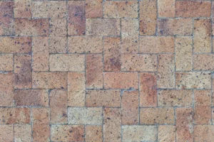 Close-up of a textured brick paver pattern arranged in a herringbone layout, ideal for driveways.