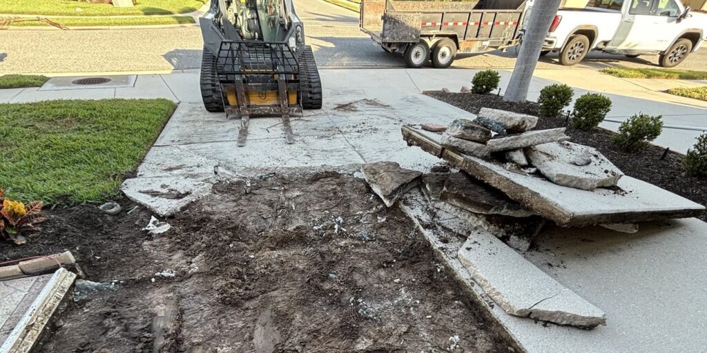 Concrete Driveway Removal in Venice, FL: What to Know 1 Concrete driveway demolition with equipment and hauling trailer